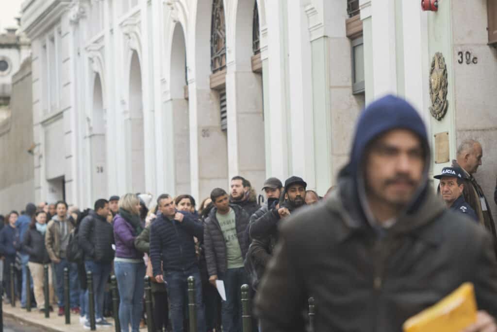 Conjunto de pessoas em uma fila nas ruas de Portugal