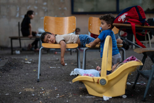 Um menino dorme em cadeiras na escola onde sua família está abrigada depois de ser deslocada por ataques aéreos israelenses em Sidon, também conhecida como Saida, no Líbano.