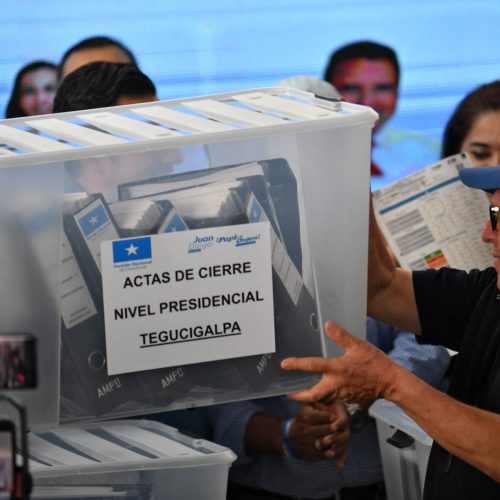 A box with electoral material is carried during the vote count in Tegucigalpa, on December 4, 2025. Right-wing businessman Nasry Asfura, supported by US President Donald Trump, regained the lead in the Honduran presidential election count on Thursday, although he remains in a technical tie with television presenter Salvador Nasralla. (Photo by Orlando SIERRA / AFP)