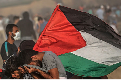 Palestinos se protegem do gás lacrimogêneo israelense durante confrontos perto da fronteira entre Israel e a Faixa de Gaza.